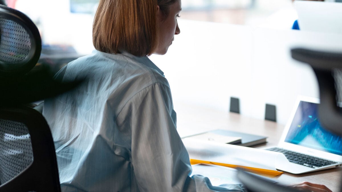 Eine Frau sitzt in einem ergonomischen Schreibtischstuhl im Büro.